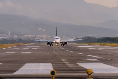 Karadağ 'ın Tivat Havalimanı' nın gün batımı görünümü ve kalkış uçağı