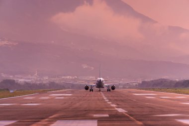 Karadağ 'ın Tivat Havalimanı' nın gün batımı görünümü ve kalkış uçağı