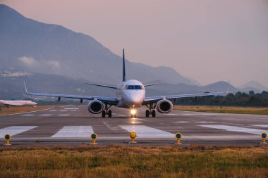 Karadağ 'ın Tivat Havalimanı' nın gün batımı görünümü ve kalkış uçağı