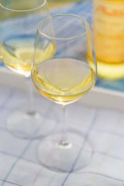 Vista al atardecer de dos copas de vino y botella de vino blanco en el — Foto de Stock