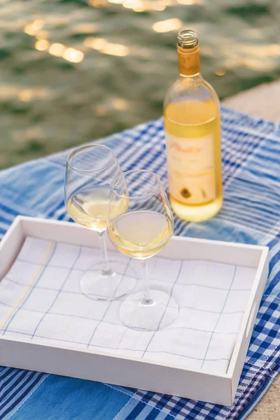 Вид на закат из двух бокалов вина и бутылки белого вина — стоковое фото