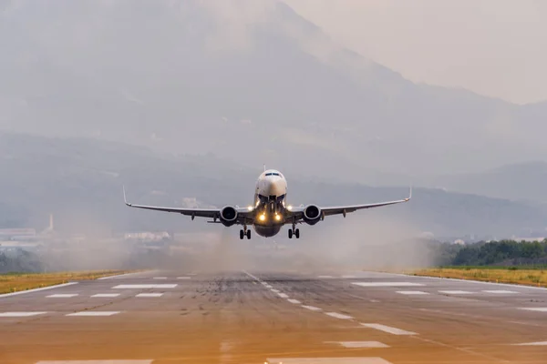 Karadağ 'ın Tivat Havalimanı' nın gün batımı görünümü ve kalkış uçağı