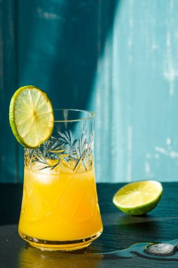 Soğuk yaz kireç ve buzlu lezzetli kuyruk siyah taş arka planda damla damlatan bir bardak..