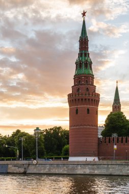 Moskova Kremlin ve Bolşoy Kamenny Köprüsü 'nün klasik manzarası şafak vakti mavi gökyüzü ve parlak turuncu ufuk ile Moskova Nehri üzerinde.