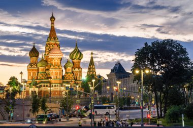 Moskova Kremlin ve Bolşoy Kamenny Köprüsü 'nün klasik manzarası şafak vakti mavi gökyüzü ve parlak turuncu ufuk ile Moskova Nehri üzerinde.