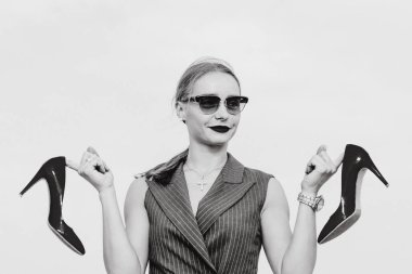 Şık beyaz genç kadının elleri açık parlak yüksek topuklu ayakkabı ile ayakta elbiseli, güneş gözlüğü, tek renkli portre 