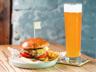 Light bira ve et, peynir, domates, turşu, patates kızartması tablosundaki fat burger