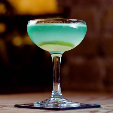 yeşil ve mavi kireç alkolle kokteyl cam masanın üzerinde çubuk