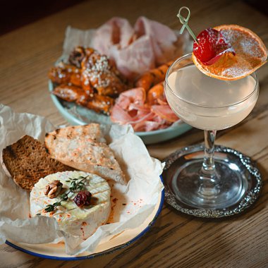 sosis, jambon, jamon ve pişmiş camembert peyniri ve portakal ve vişne tarafından dekore edilmiş alkol kokteyl ile iştah açıcı et tabağı