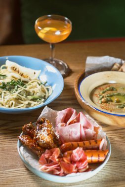 Mavi Plaka, Humus, antipasti ve kokteyl masanın üzerine krem soslu makarna