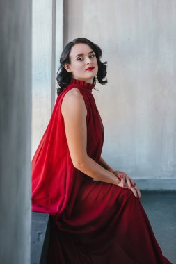 pencerenin yanında kırmızı uzun elbiseli güzel genç esmer muse kadın portresi
