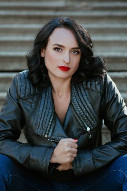 deri ceket ve kot açık merdivenlerde oturan esmer kadın portresi