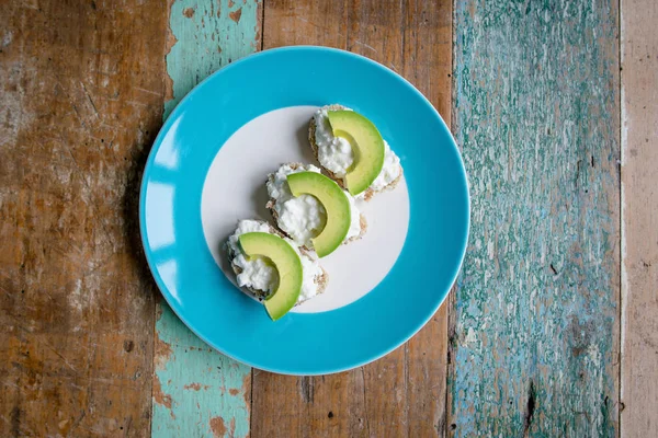 sandwich: healthy bread with seeds with cream cheese and avocado on the plate on the table