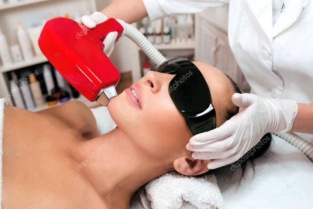 Beautiful woman face on laser hair removal at epilation cabinet