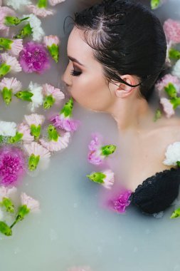 güzel seksi üzgün genç ince esmer kadın Spa - banyo su ve çiçekler