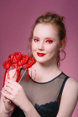 küpe ve ile güzel çekici şık gülen genç Kızıl saçlı kadın portresi saint valentine's day süslemeleri (kupa) elleri ile makyaj