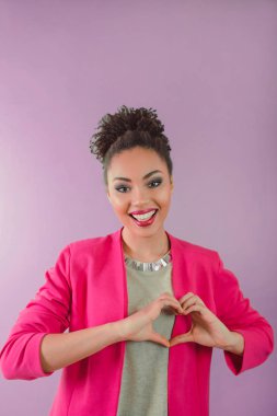 güzel çekici neşeli gülümseyen genç kadın (karışık rase) kalp ellerini tutarak ve aşkını gösterilen