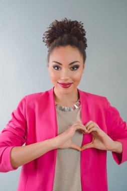 güzel çekici neşeli gülümseyen genç kadın (karışık rase) kalp ellerini tutarak ve aşkını gösterilen