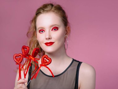 küpe ve ile güzel çekici şık gülen genç Kızıl saçlı kadın portresi saint valentine's day süslemeleri (kupa) elleri ile makyaj