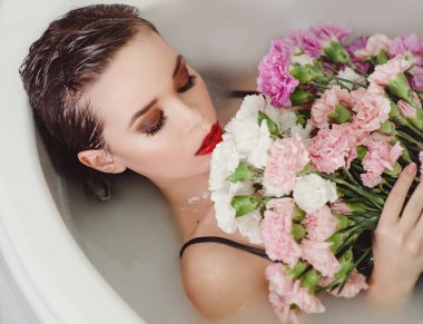 güzel seksi üzgün genç ince esmer kadın banyo Spa ile karanfil çiçek