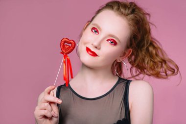 küpe ve ile güzel çekici şık gülen genç Kızıl saçlı kadın portresi saint valentine's day süslemeleri (kupa) elleri ile makyaj