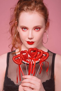 güzel çekici şık genç Kızıl saçlı kadın portresi makyaj saint valentine's day dekorasyon (kupa) ile onun elinde tonlama yaşam mercan ile