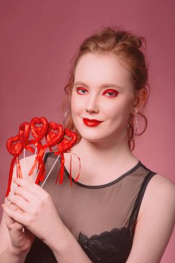 küpe ve ile güzel çekici şık gülen genç Kızıl saçlı kadın portresi makyaj saint valentine's day dekorasyon (kupa) ile onun elinde tonlama yaşam mercan ile