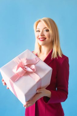 güzel sarışın kadınla kollarını mavi arka plan üzerinde mevcut kutusunda blazer içinde gülümseyen