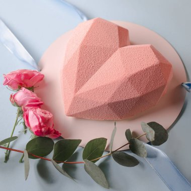 Şık modern bir tasarım pembe kalp şeklinde pasta gül ile mavi arka plan üzerinde