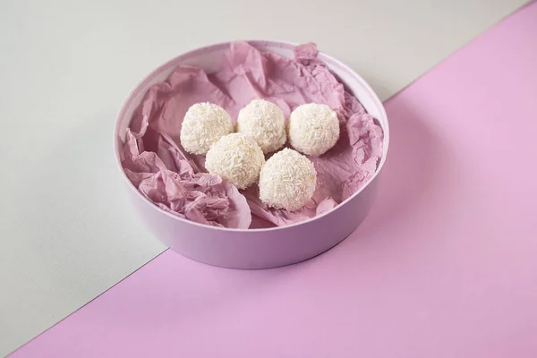 delicious handmade coconut sweets in round box on grey and velvel (purple) background