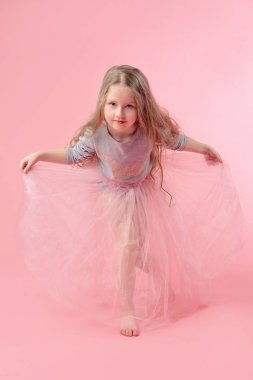 pembe arka planda uzun sarışın saçlı sevimli komik küçük kız