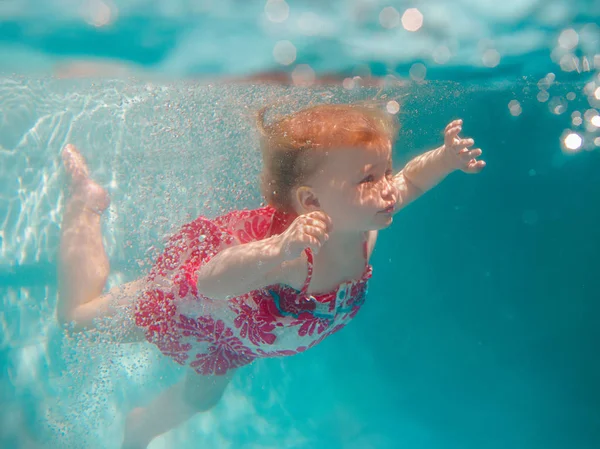 微笑的女婴在可爱的现代礼服潜水在蓝色游泳池水下 积极的生活方式 儿童游泳课与家长 热带度假家庭暑假期间的水上运动 — 图库照片