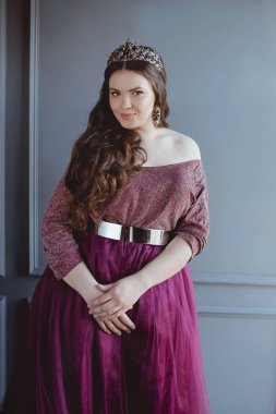 uzun saç ve minimalist iç kapalı makyaj uzun mor kraliçenin elbise ve taç, güzel genç güzel sevimli kadın Prenses (Kraliçe) portre