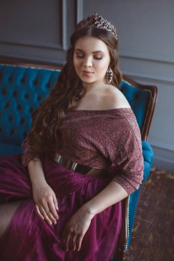 uzun saç ve minimalist iç kapalı makyaj uzun mor kraliçenin elbise ve taç, güzel genç güzel sevimli kadın Prenses (Kraliçe) portre