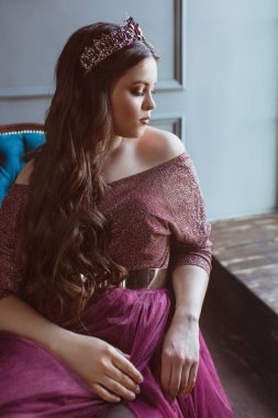 uzun saç ve minimalist iç kapalı makyaj uzun mor kraliçenin elbise ve taç, güzel genç güzel sevimli kadın Prenses (Kraliçe) portre