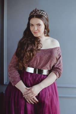 uzun saç ve minimalist iç kapalı makyaj uzun mor kraliçenin elbise ve taç, güzel genç güzel sevimli kadın Prenses (Kraliçe) portre