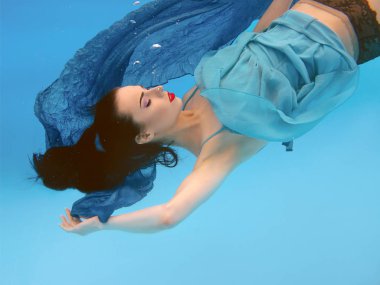 gerçeküstü, konsept, mavi arka plan üzerinde yüzme havuzunda sualtı makyaj ile güzel güzel esmer genç kadının sanat portresi 