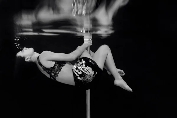 黒い背景のスイミングプールでポールを持つ若い フィット スリムな女性のモノクロの肖像画 — ストック写真