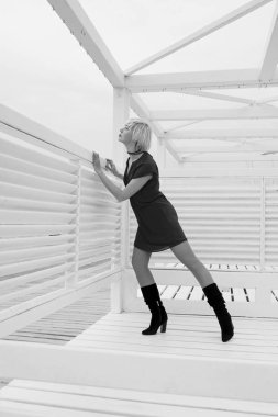 deniz kenarında plaj için ahşap beyaz çardak yakınında kısa yaz elbise li oldukça serin güzel kısa saç sarışın kadın monokrom portre