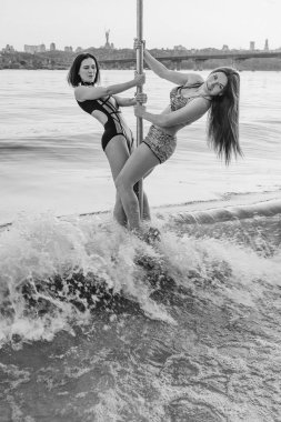 Akşam (gün batımı) cityscape arka plan üzerinde nehir Dinyeper üzerinde nehir Dinyeper üzerinde kutup üzerinde uzun saçlı iki ince, uygun, atletik güzel kadın çifti)