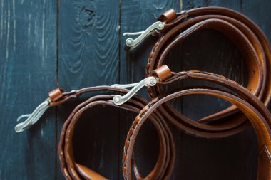 koyu ahşap arka planda üç deri kahverengi kemer