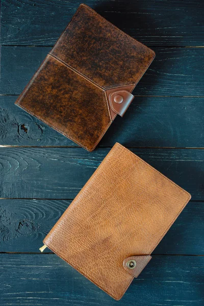 two leather handmade notebooks (organizer) on dark wooden background