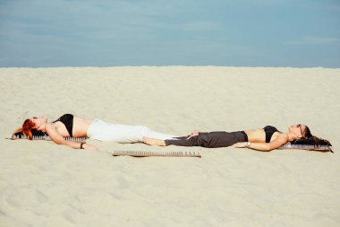 aşırı yoga gevşeme ve kendini geliştirme - güzel kadınlar çöl açık çivi ile tahtaya geri nacked döşeme