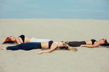 aşırı yoga gevşeme ve kendini geliştirme - güzel kadınlar çöl açık çivi ile tahtaya geri nacked döşeme