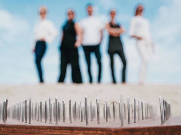 extreme yoga relaxation and self-development training for office people laying and standing on the board with nails in desert outdoor