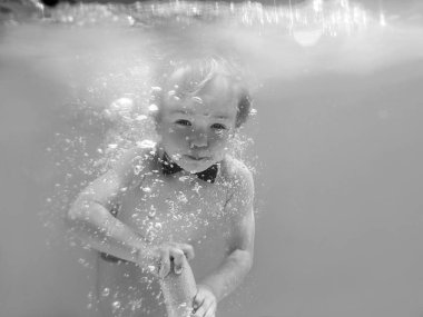 Kırmızı Kelebek ile küçük komik neşeli çocuk çocuk ve yüzme havuzunda su tabancası dalış sualtı, yüzmeyi öğrenmek. Spor ve tatil konsepti