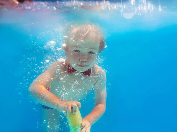 赤い蝶と水銃で水中ダイビングと小さな面白い陽気な子供の男の子は 泳ぐことを学びます スポーツと休暇のコンセプト — ストック写真