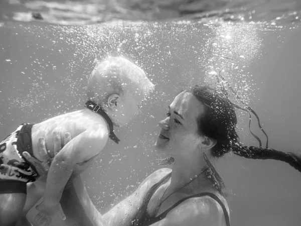 美丽的年轻女子 与可爱的小男孩在蝴蝶 她的儿子 在水下的游泳池 学习游泳 爱情和度假理念 — 图库照片