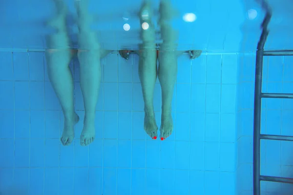 スイミングプールで水中で2人の足 パーティー 多様性 スポーツの概念 — ストック写真