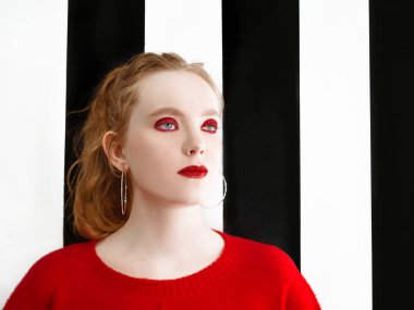 şık makyaj ve siyah beyaz arka plan üzerinde kırmızı kazak ile güzel genç kızıl saçlı kadın portresi